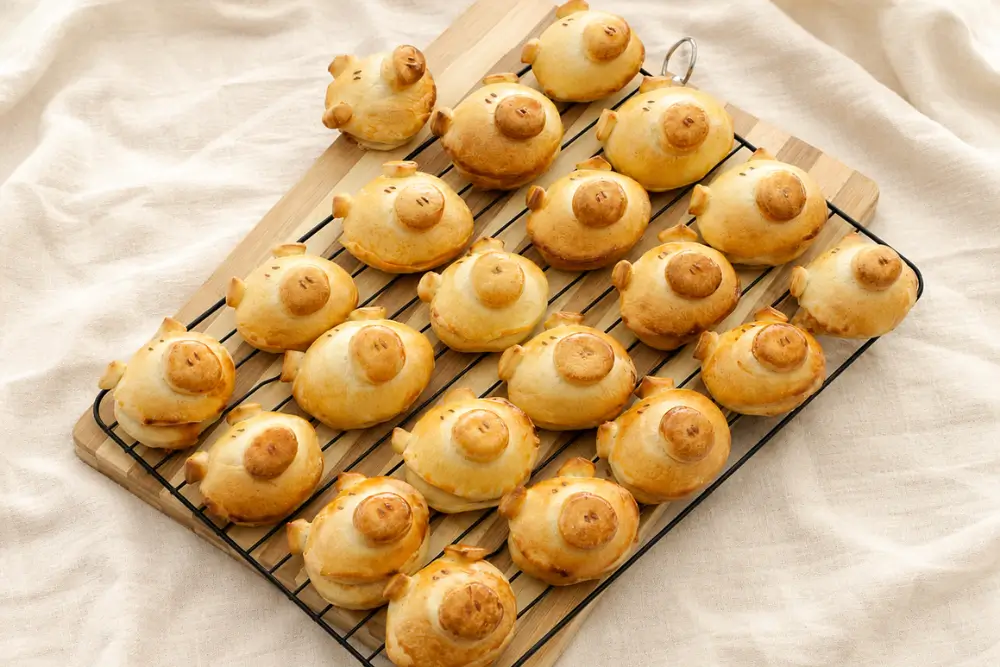 Golden Pizza Flavoured Piggy Buns cooling on a wire rack.