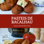 Golden Pasteis de Bacalhau stacked on a plate with lemon wedges and tomato in the background.