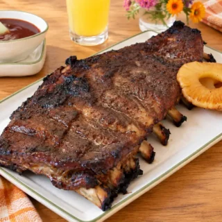 Pineapple Pork Ribs with Coconut Glaze served with pineapple rings and homemade barbecue sauce.