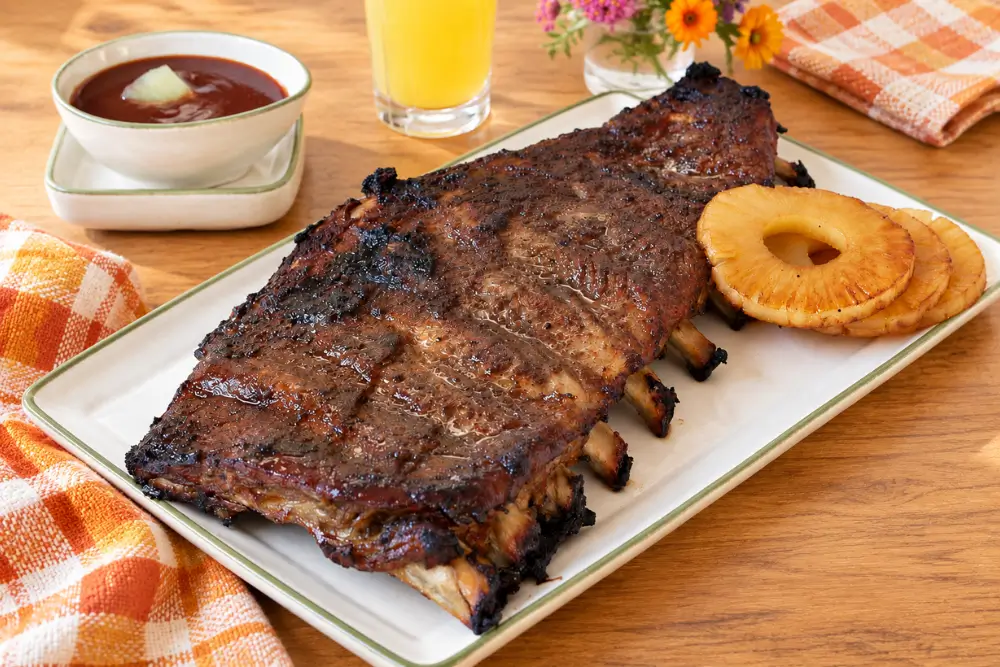 Pineapple Pork Ribs with Coconut Glaze served with pineapple rings and homemade barbecue sauce.