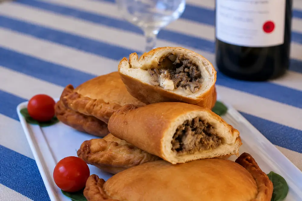 Fried Apulian panzerotti arranged on a serving platter with cherry tomatoes.