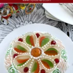 "Whole Cassata Siciliana decorated with colorful candied fruits and white icing, placed on a lace tablecloth.