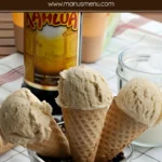 Kahlúa coffee ice cream scoops in cones with a bottle of liqueur in the background.