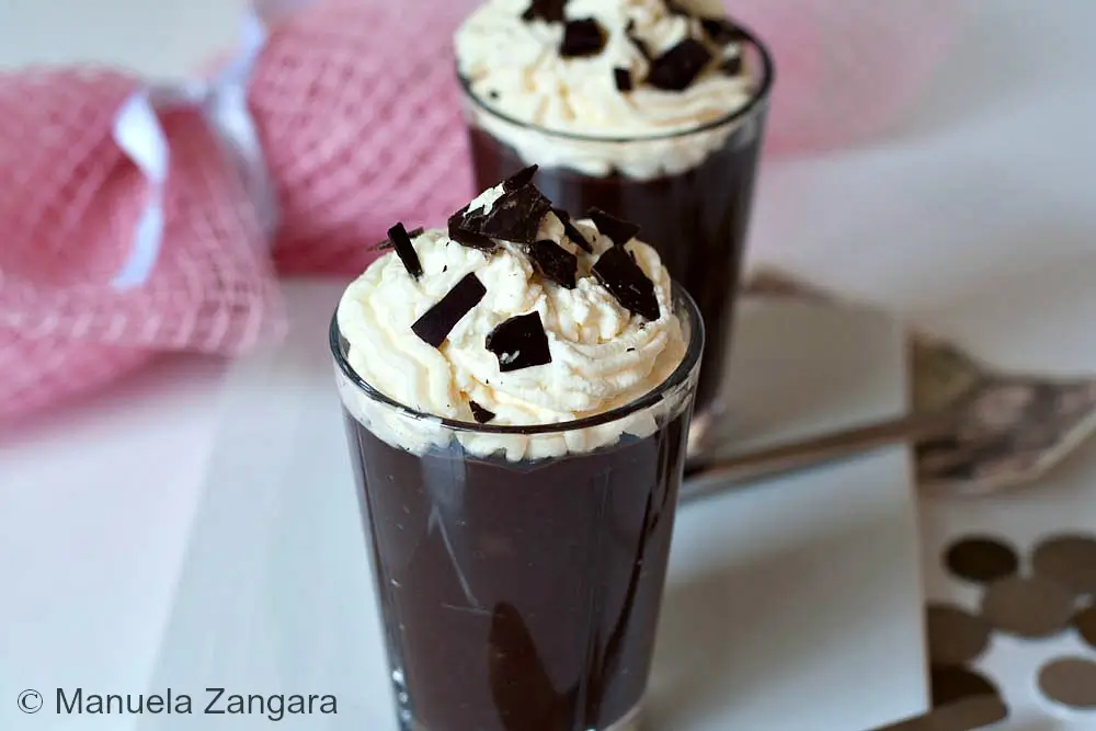 Glass of chilled Crème Viennoise Chocolat topped with piped Chantilly and chocolate shavings.