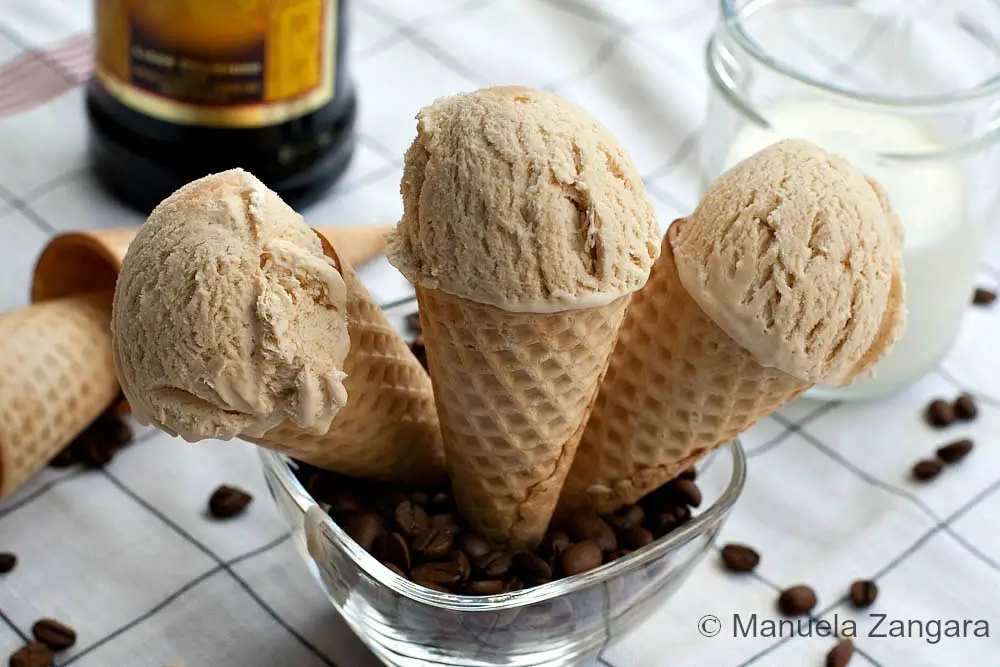 Scoops of Kahlúa coffee ice cream served in waffle cones with coffee beans.