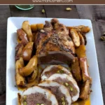 Sliced chicken ballotine filled with minced meat and pistachios served with roasted apples on a white plate.