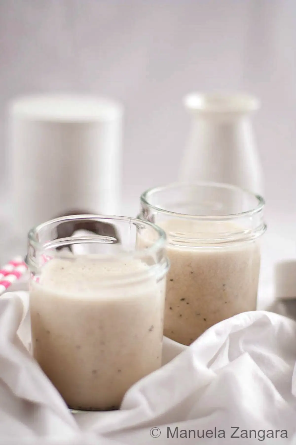 Banana Passion Fruit Smoothie served in small glass jars on a light background.