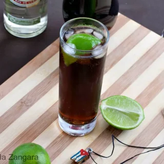 Close-up of a Cuba Libre with lime and ice.