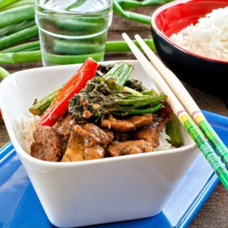 Honey and Ginger Pork Stir Fry served over steamed rice with broccolini and capsicum.