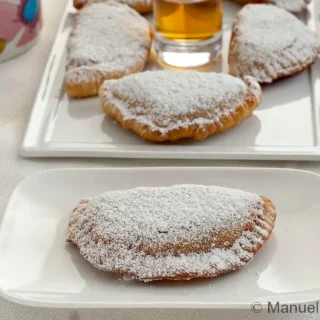 Fried cassatella dusted with icing sugar and filled with ricotta and chocolate.