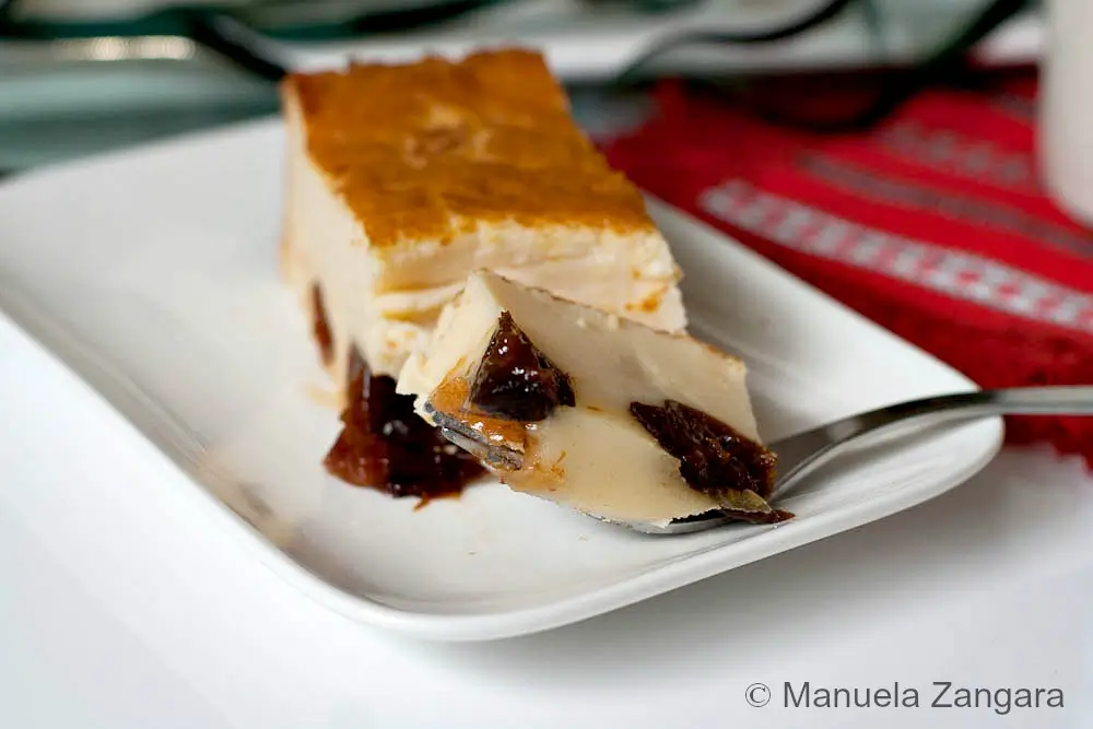 Slice of Far Breton on a plate with prunes visible in the custard.