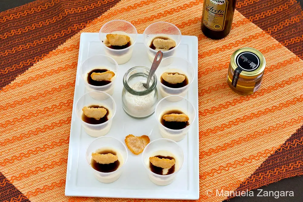 Platter of chilled savoury cheese panna cotta topped with balsamic glaze and Parmigiano crisps.