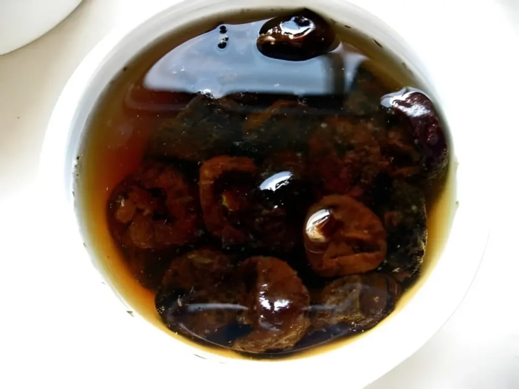 Bowl of prunes soaking in rum and warm water.