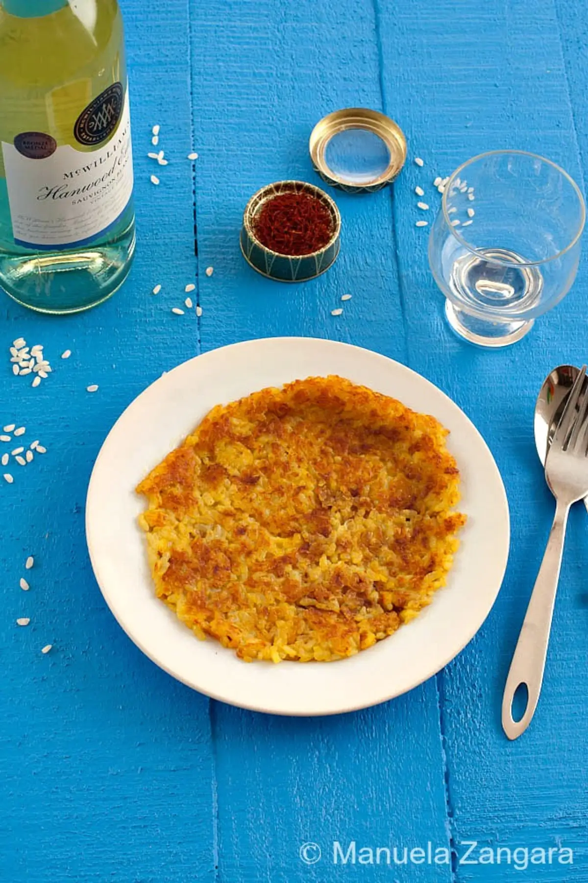 Saffron risotto fried in a pan until crisp and golden on both sides.