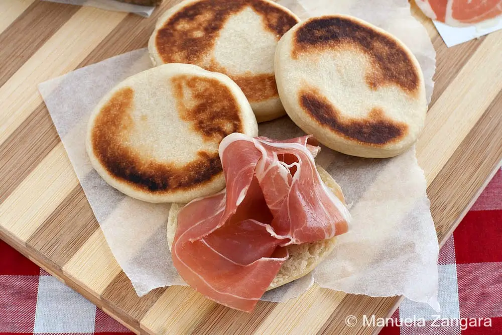 Warm flatbread sliced open and topped with thin prosciutto.