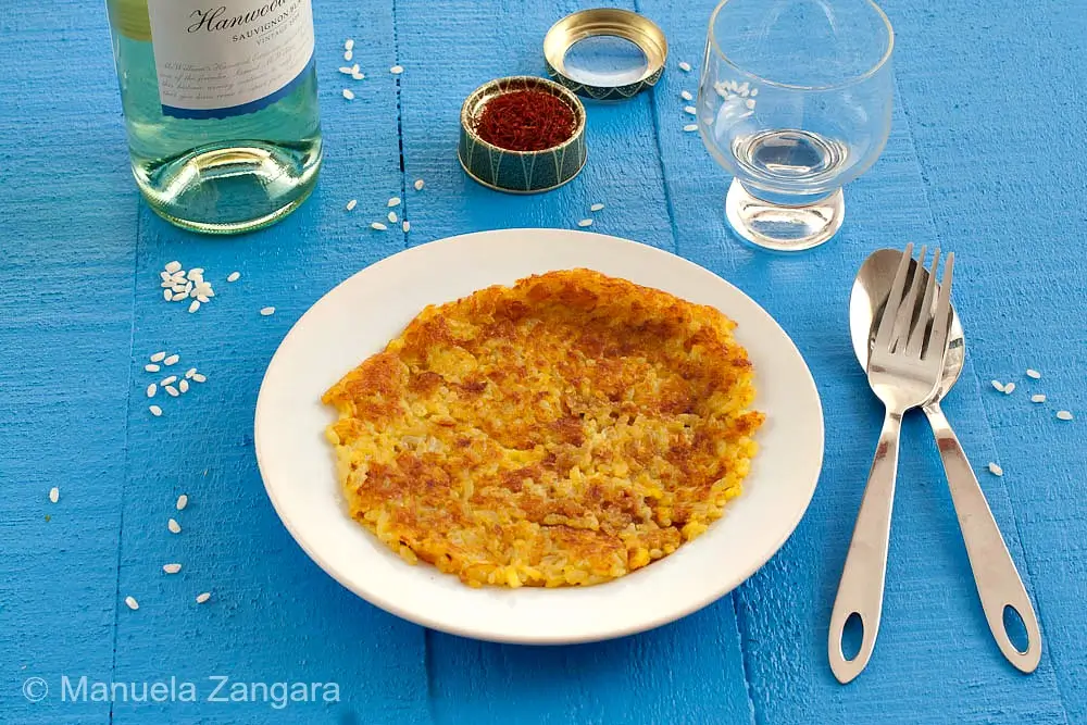 Riso al Salto served on a plate with golden crust and crisp edges.