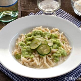 Bowl of trofie pasta topped with zucchini cream sauce.