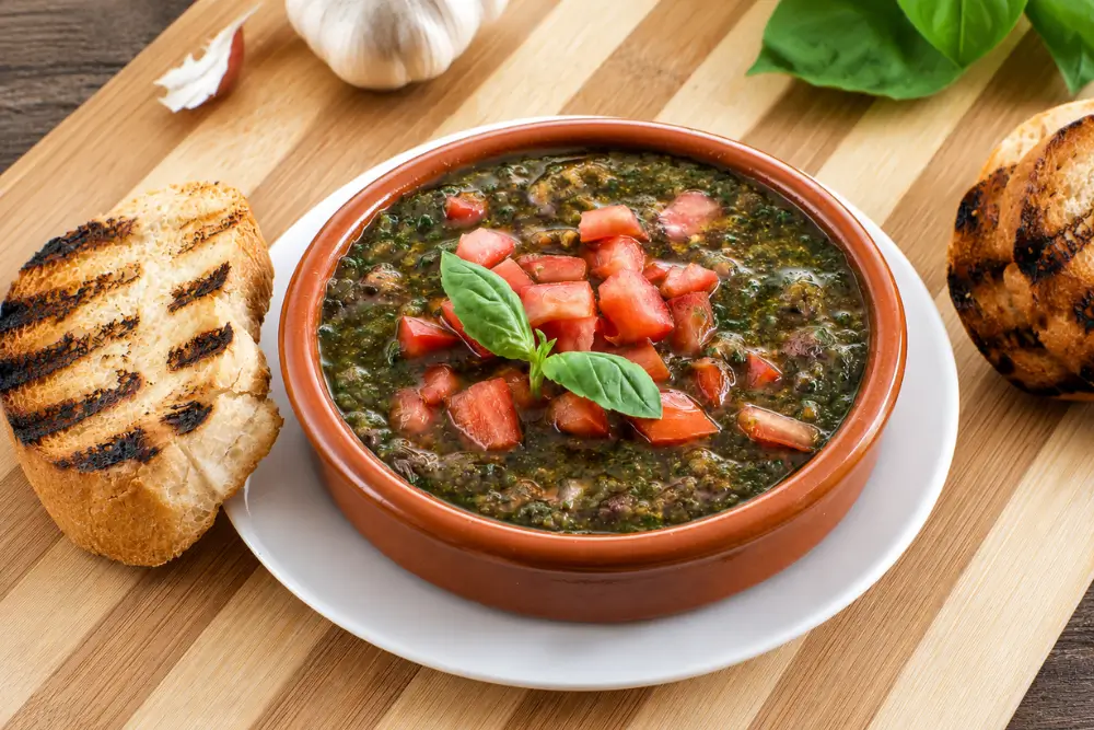Bowl of Sicilian Matarocco topped with diced tomatoes and basil served with grilled crostini.