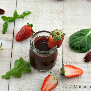 Finished strawberry balsamic vinegar with whole and sliced strawberries.