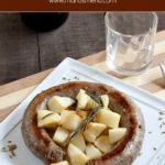 Close-up of pan-fried sausage with golden potatoes and fennel seeds.