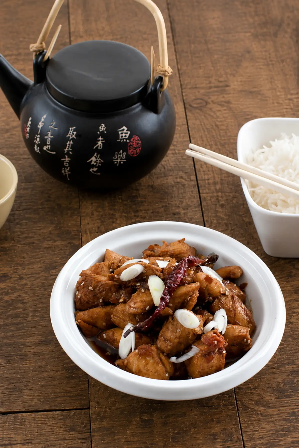 Chicken pieces coated in ginger sesame sauce and garnished with spring onions and dried chilli.