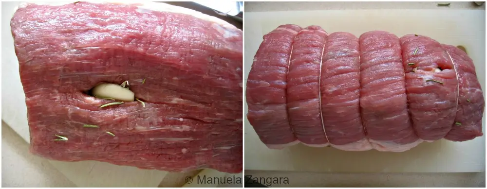 Meat prepared with garlic inside the slits and tied with kitchen string.
