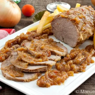 Sliced beef roast topped with onion glaze and served with fries.