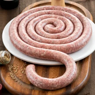 Homemade Sicilian Pork Sausage with Fennel coiled on a white plate.
