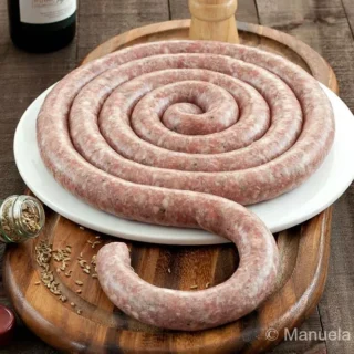 Homemade Sicilian Pork Sausage with Fennel coiled on a wooden board.