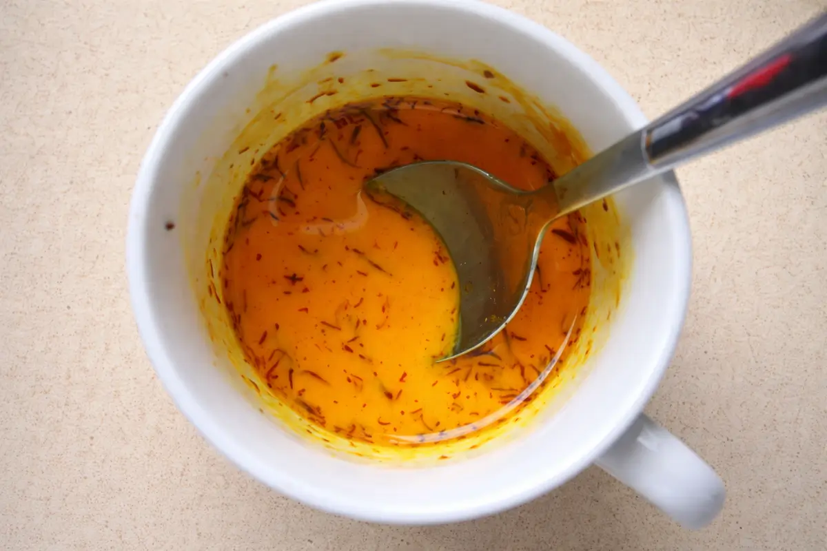 Saffron threads soaking in warm milk.