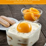 Peach Tiramisù layered with mascarpone cream and topped with a peach half.