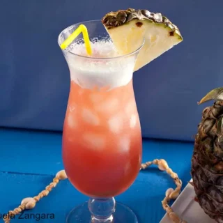 A Mai Tai served over ice with a frothy top and pineapple garnish.