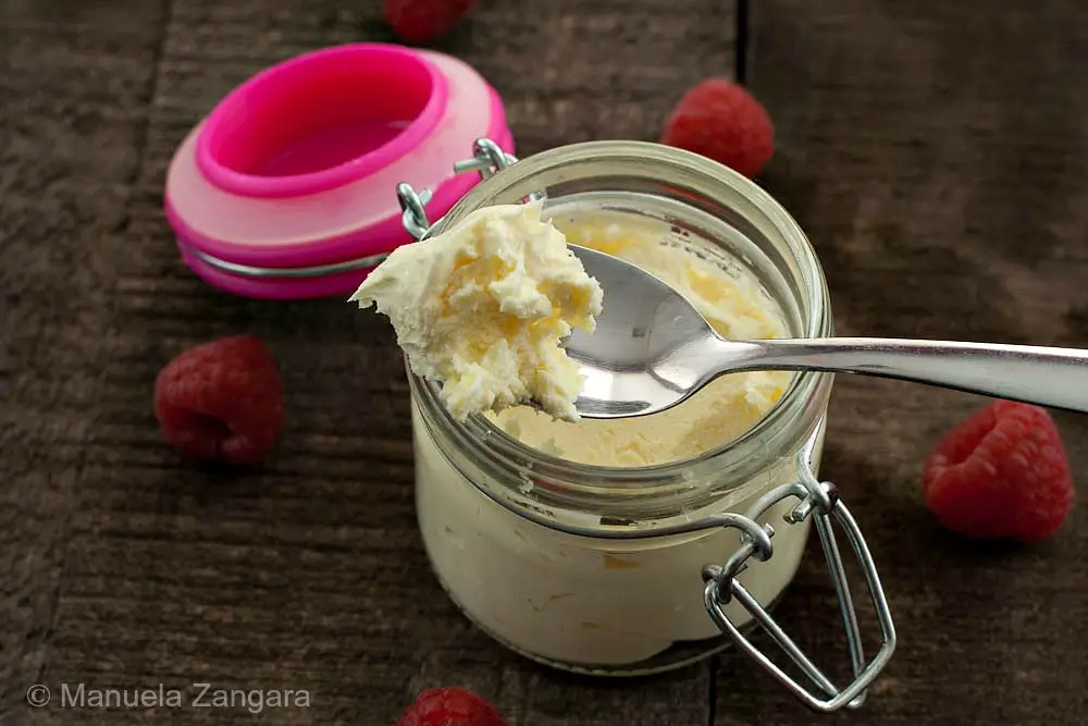 Homemade mascarpone cheese stored in a glass jar.