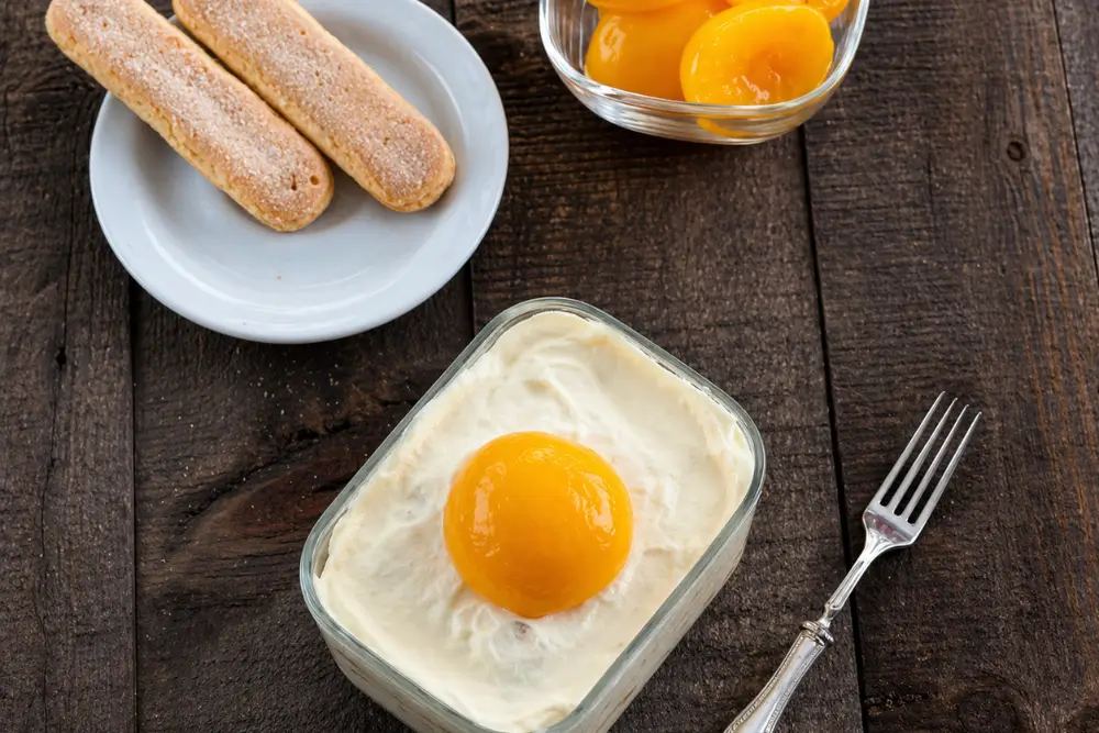 Chilled no-bake peach dessert with creamy mascarpone layers and peach topping.