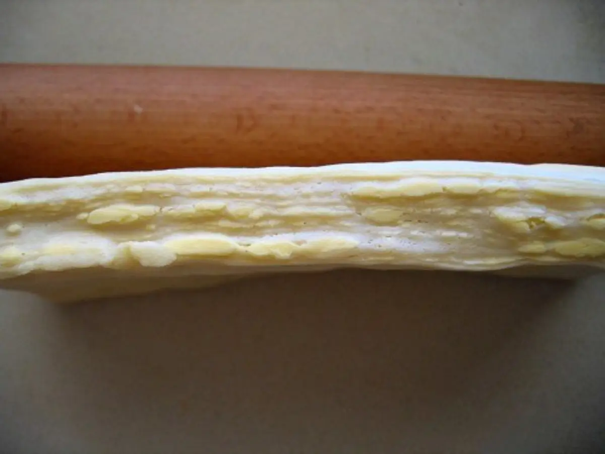 Cross-section of croissant dough showing visible butter layers after lamination.