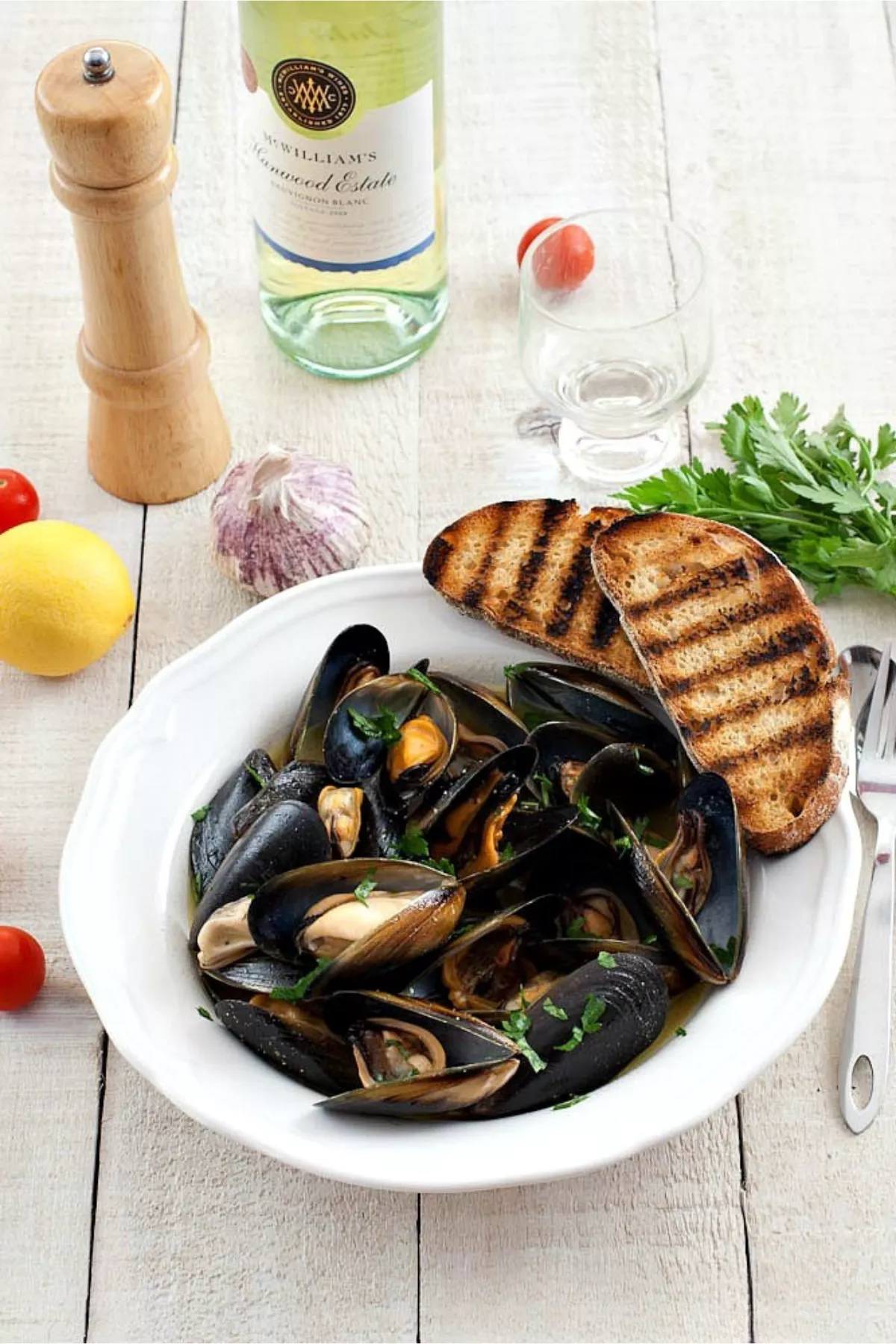 Bowl of steamed mussels with parsley, garlic, and grilled bread for Impepata di Cozze.