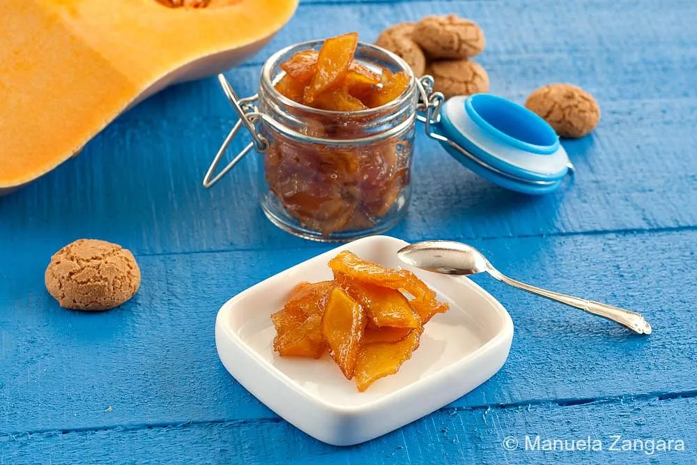 Close-up shot of Mostarda Mantovana in a jar, served on a white plate.