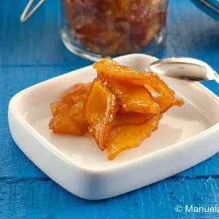 A serving of Mostarda Mantovana in a small white dish with a spoon.