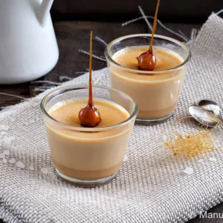 Close-up of caramel panna cotta with a caramel-dipped hazelnut on top.
