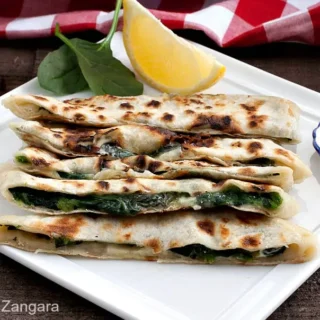 Spinach and feta gozleme with browned flatbread edges.