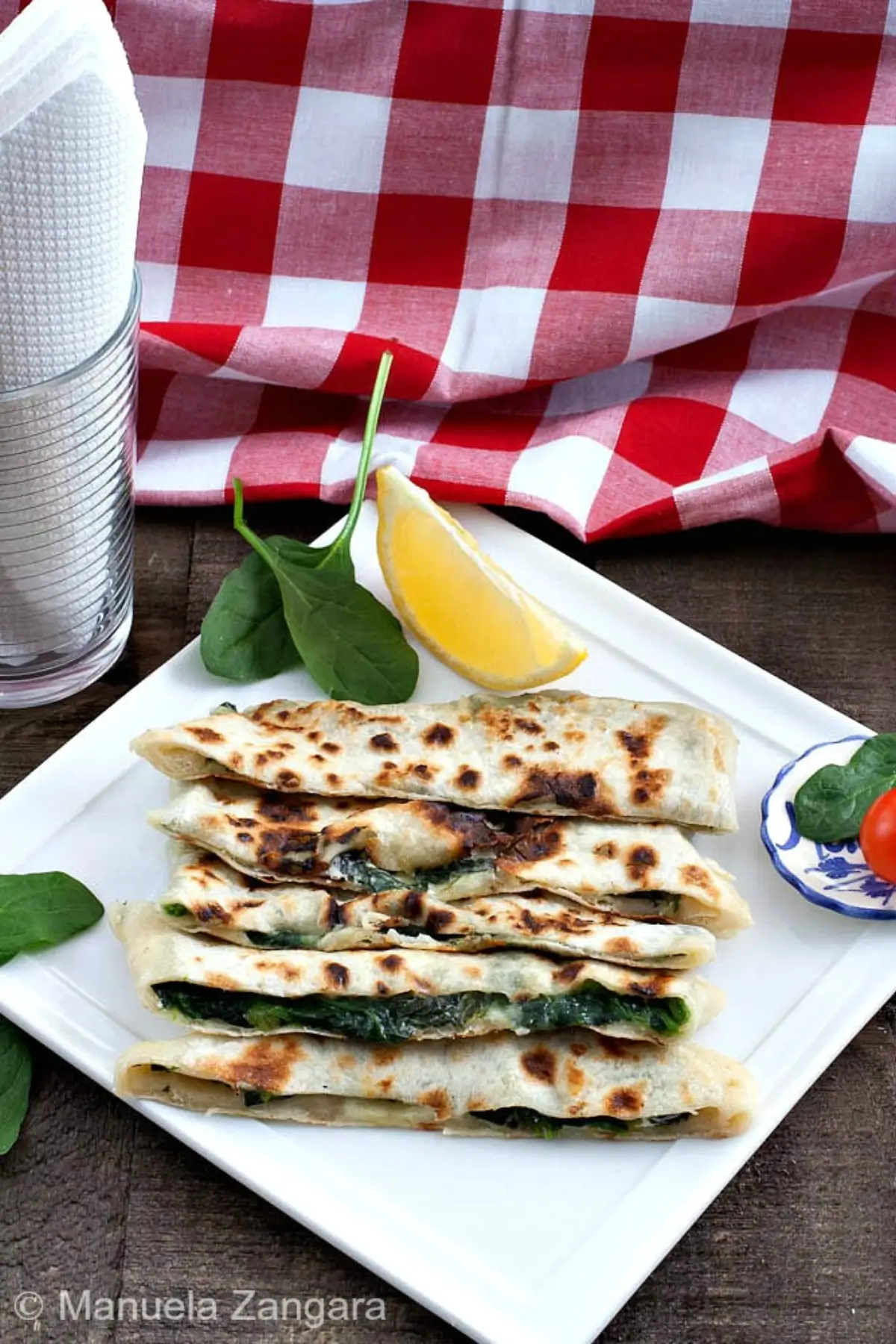 Spinach and feta gozleme sliced and stacked on a plate.