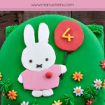 Finished Miffy Cake decorated with green fondant, flat Miffy design, balloon detail, and small fondant flowers.