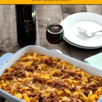 Baked Pasta al Forno topped with rich meat sauce and melted cheese in a white baking dish on a rustic wooden table.