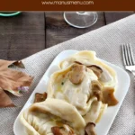 Cappellacci served on a plate with porcini and cream sauce.
