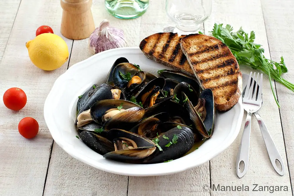 Peppered mussels served with toasted crusty bread and lemon wedges.