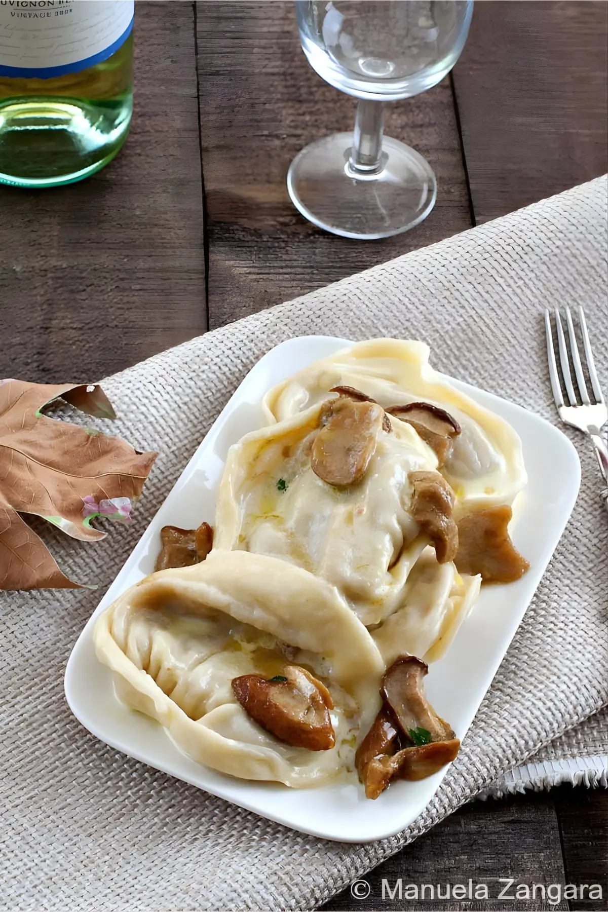 Plated cappellacci served with porcini in a cream sauce.