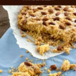 Freshly baked Sbrisolona in a tart pan topped with almonds and sugar.