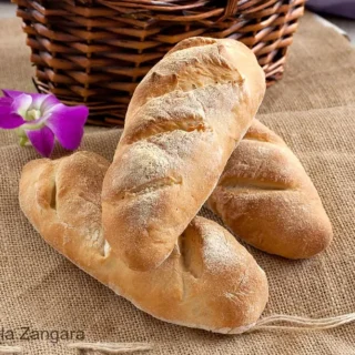 Close-up of a torn bread roll showing its soft interior.