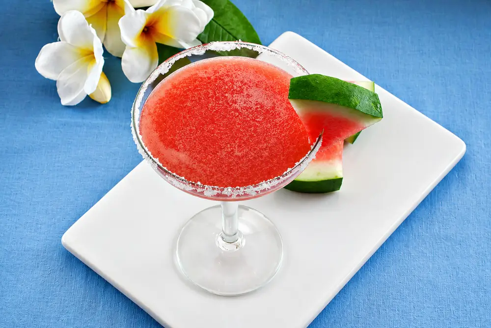 Chilled margarita served in a sugar-rimmed glass with a watermelon slice garnish.
