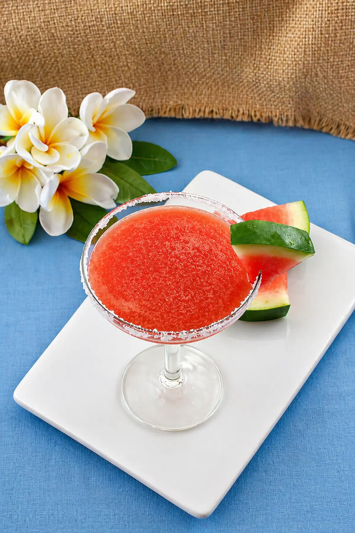 Top view of a watermelon margarita with a sugar-coated rim and fresh garnish.
